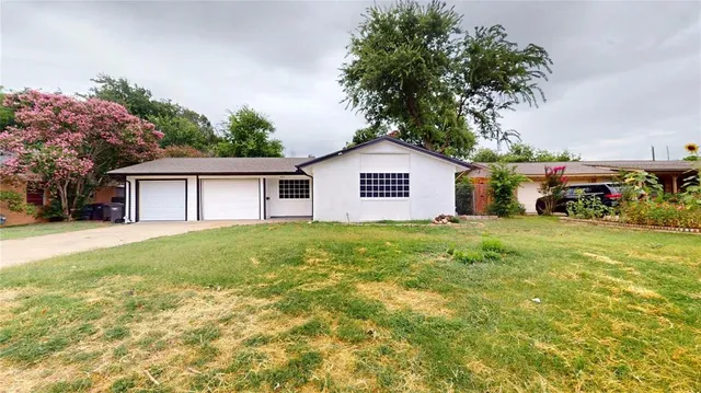 a view of a house with a big yard and potted plants