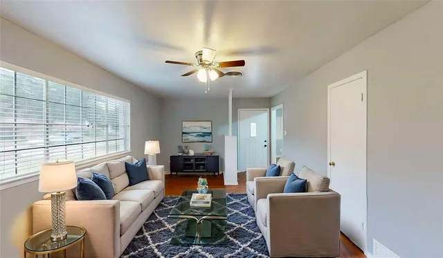 a living room with furniture ceiling fan and a window