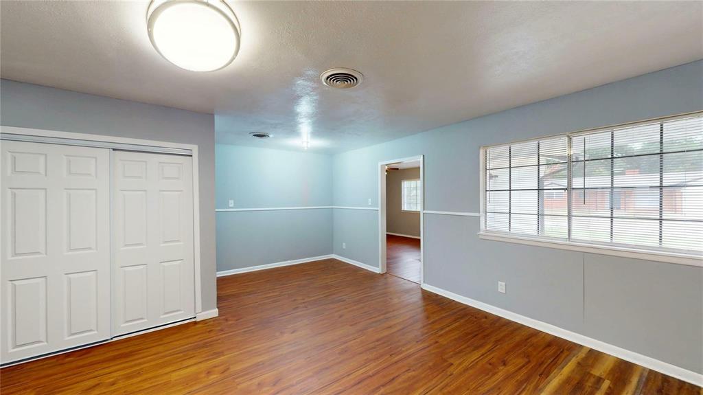 5817 Sandra Drive Fort Worth, TX 76133 - Photo 7 of 26 an empty room with wooden floor and windows