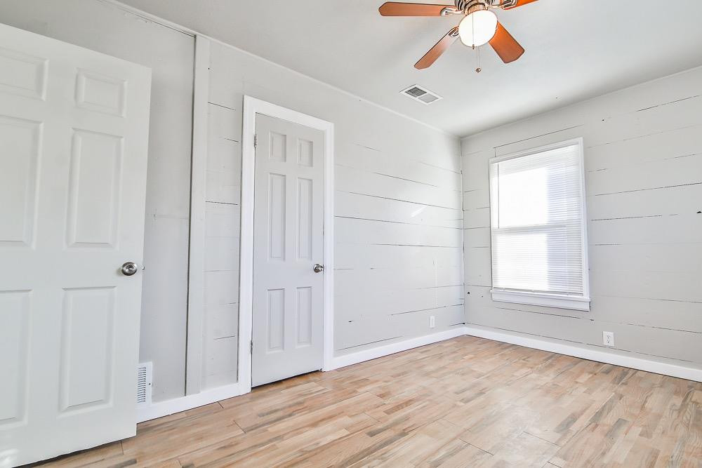 5705 County Road 1200 Lubbock, TX 79407 - Photo 26 of 29 an empty room with wooden floor chandelier fan and windows