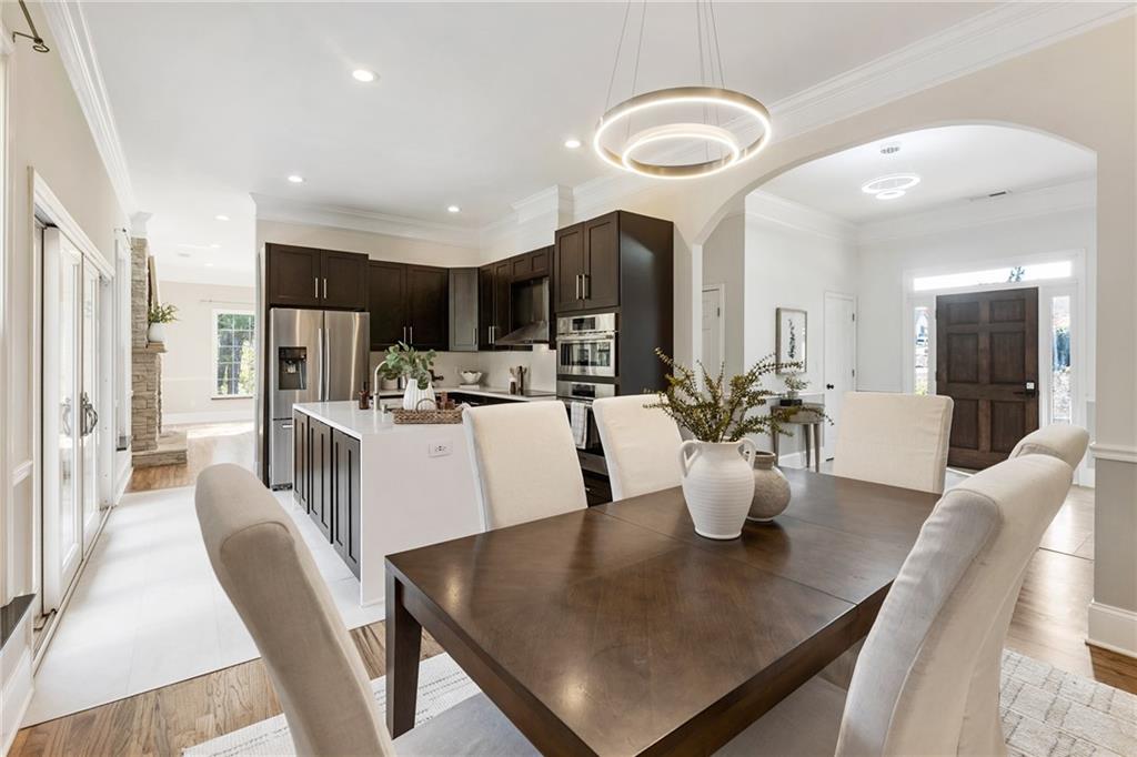 14440 Cogburn Road Alpharetta, GA 30004 - Photo 12 of 62 a dining room with kitchen island furniture a chandelier a kitchen view and a sink