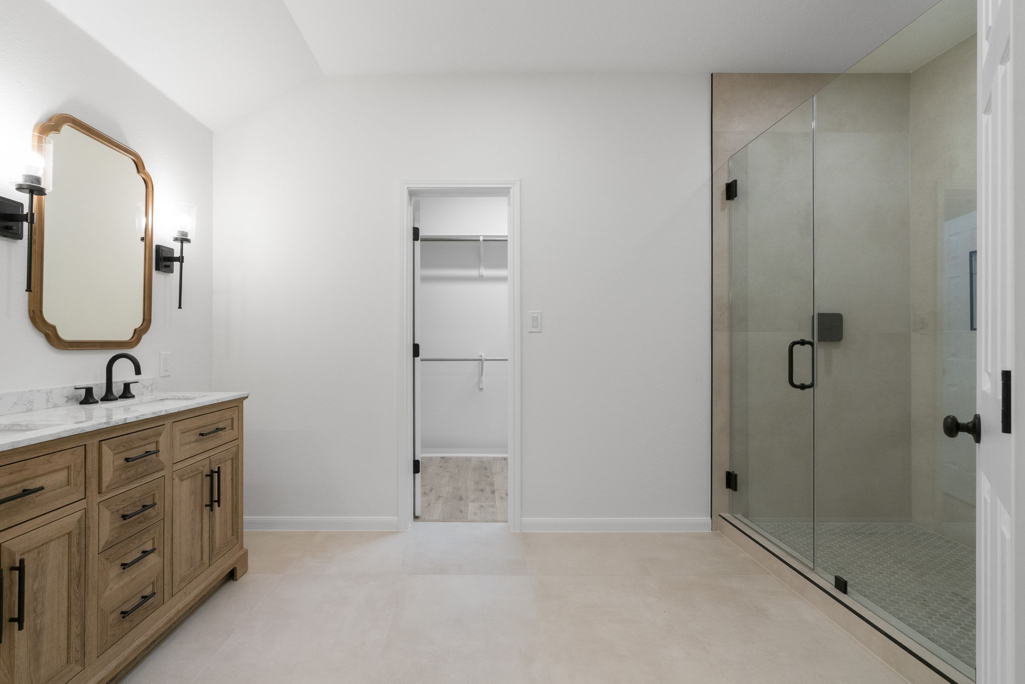 1333 Clary Sage Loop Round Rock, TX 78665 - Photo 18 of 34 Bathroom featuring a walk in closet, double vanity, and a stall shower