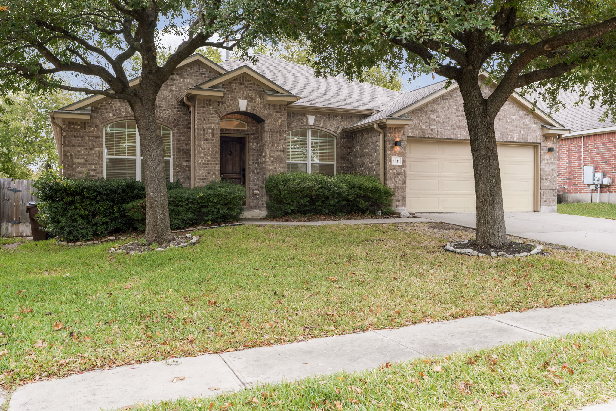 1333 Clary Sage Loop Round Rock, TX 78665 - Photo 2 of 34 Ranch-style home with brick siding, driveway, roof with shingles, and a garage