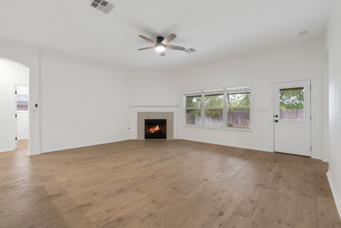 1333 Clary Sage Loop Round Rock, TX 78665 - Photo 5 of 35 wooden floor fireplace and windows in an empty room