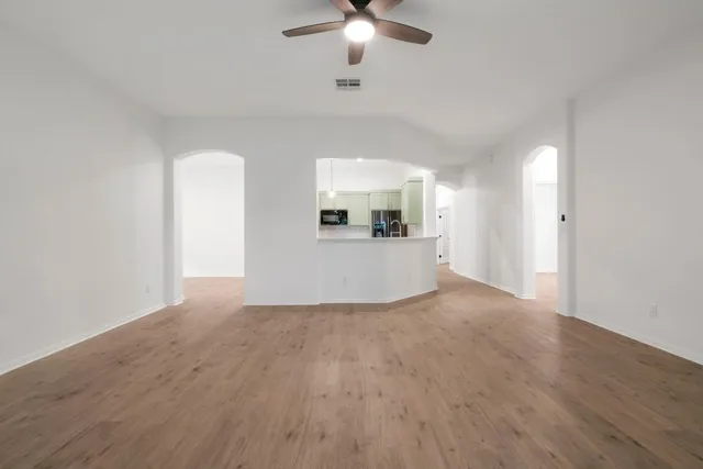 a view of a livingroom with a ceiling fan window and wooden floor