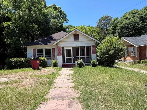 a view of a house with backyard sitting area and garden