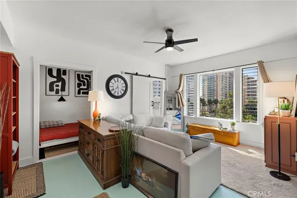 a living room with furniture a clock and a large window