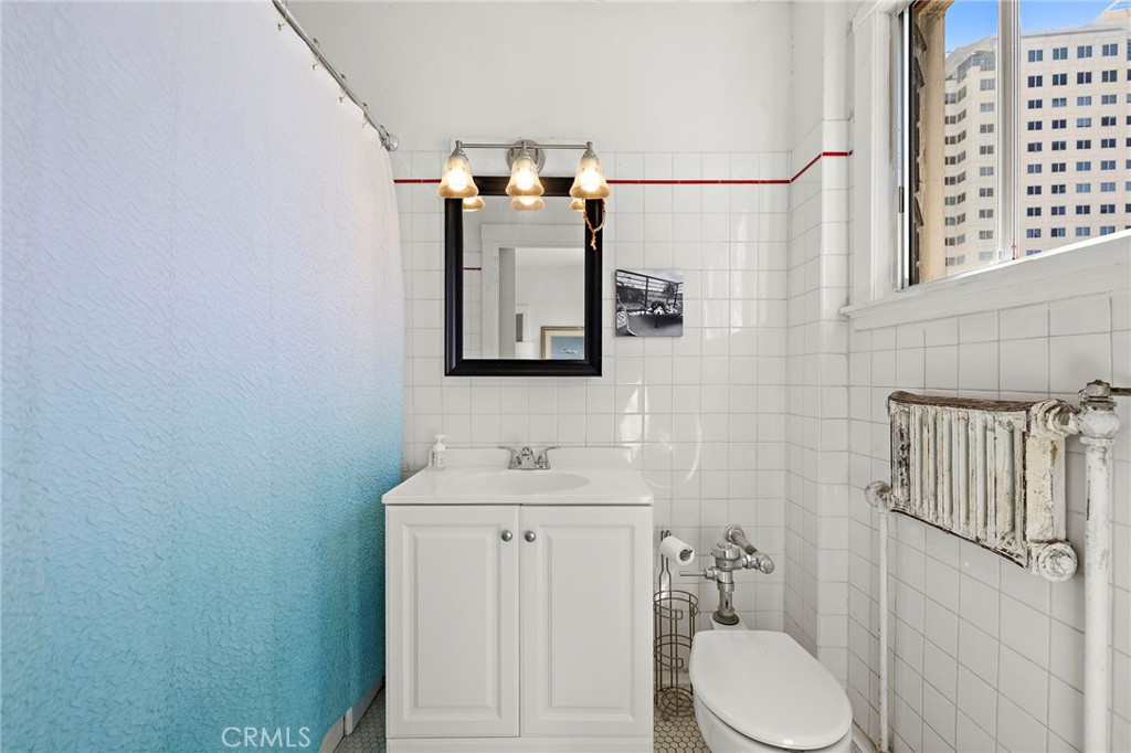 10 Atlantic Way, Unit 704 Long Beach, CA 90802 - Photo 5 of 13 a bathroom with a toilet sink and mirror
