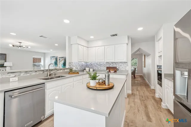 a kitchen with a sink white cabinets and counter space