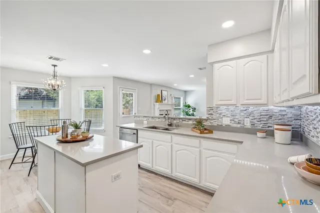 a kitchen with granite countertop a sink and cabinets