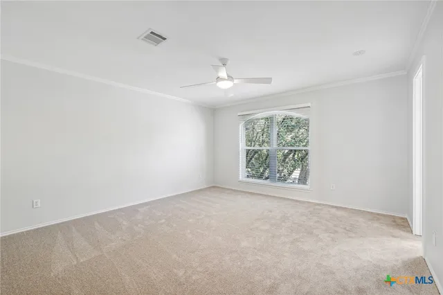 an empty room with windows and fan