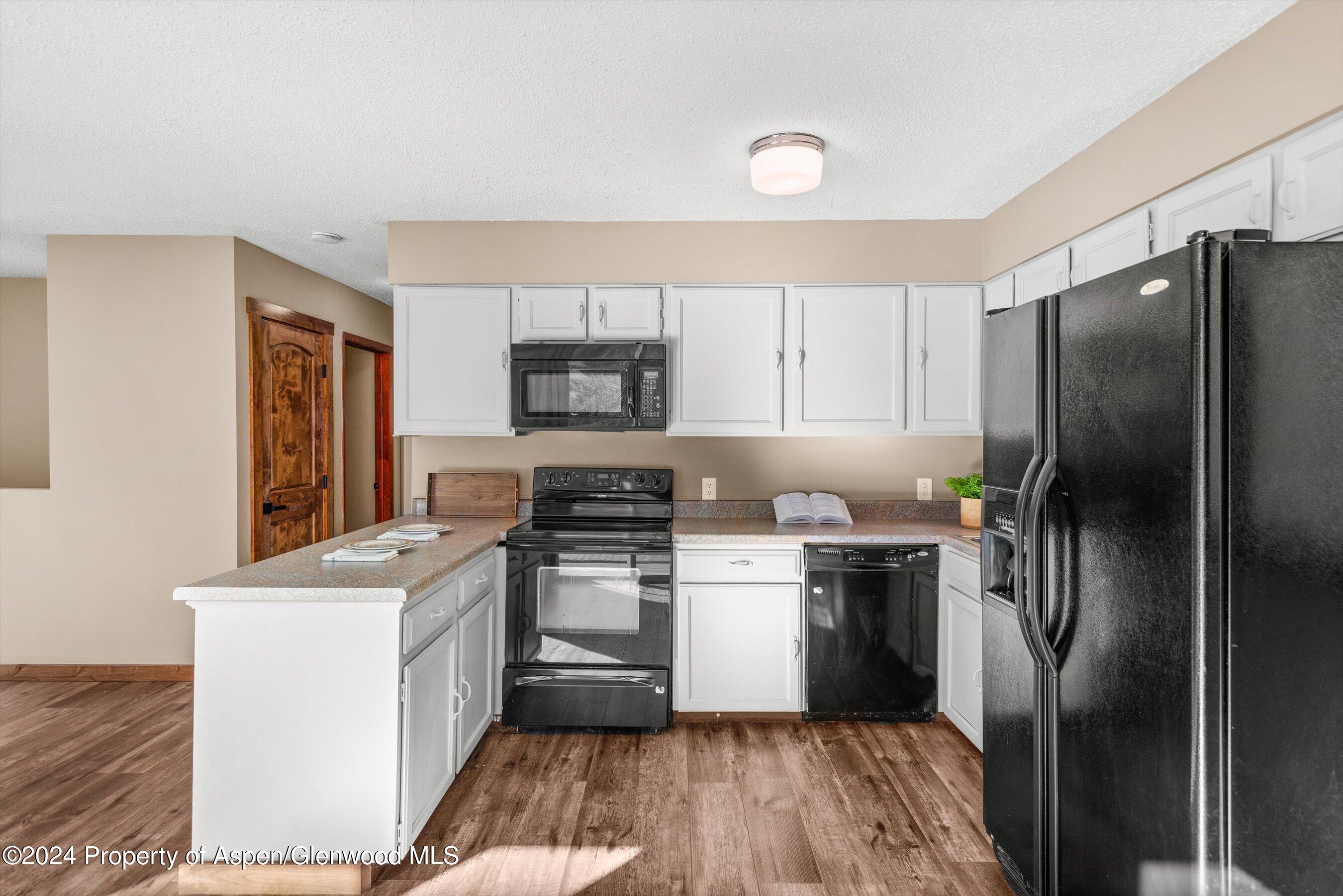 212 Cherokee Lane Carbondale, CO 81623 - Photo 12 of 34 a kitchen with a sink a refrigerator a microwave and cabinets