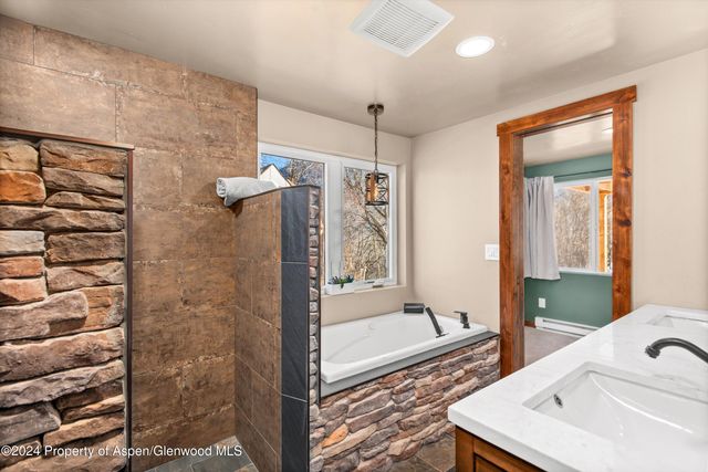 a bathroom with a tub sink and mirror
