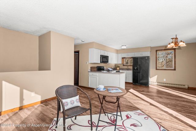 a kitchen with a dining table chairs and refrigerator