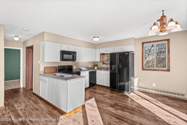 a kitchen with a refrigerator and a stove top oven