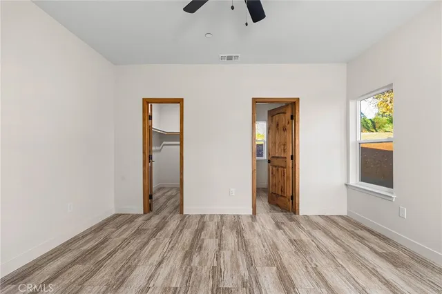 an empty room with closet and wooden floor