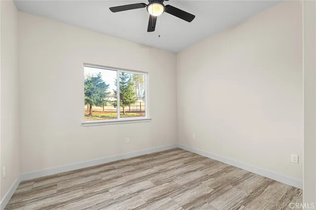 an empty room with a window and a ceiling fan
