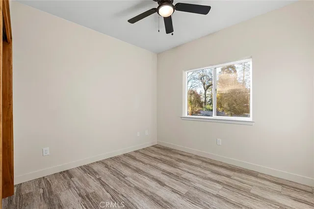 an empty room with a window and a ceiling fan