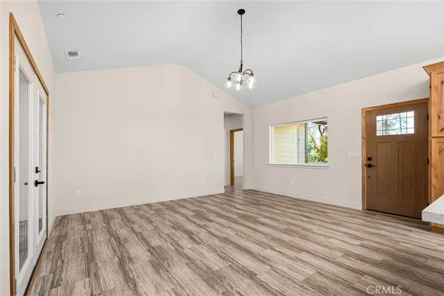 a view of empty room with wooden floor and window