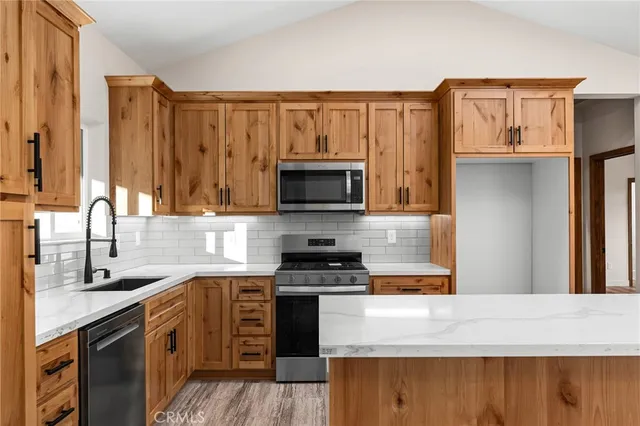 a kitchen with granite countertop a stove top oven microwave and refrigerator