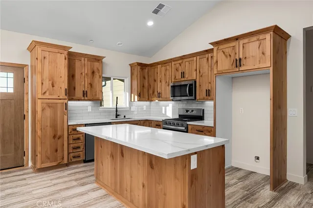 a kitchen with stainless steel appliances granite countertop a sink stove microwave and refrigerator