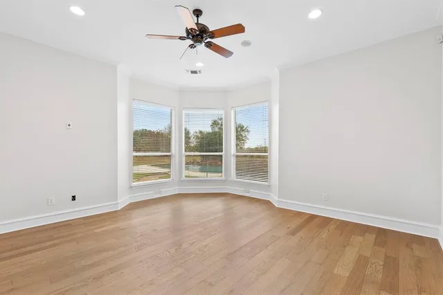 a view of room with window ceiling fan and hardwood floor