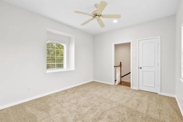 an empty room with fan and windows