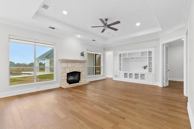 a view of empty room with wooden floor and fireplace