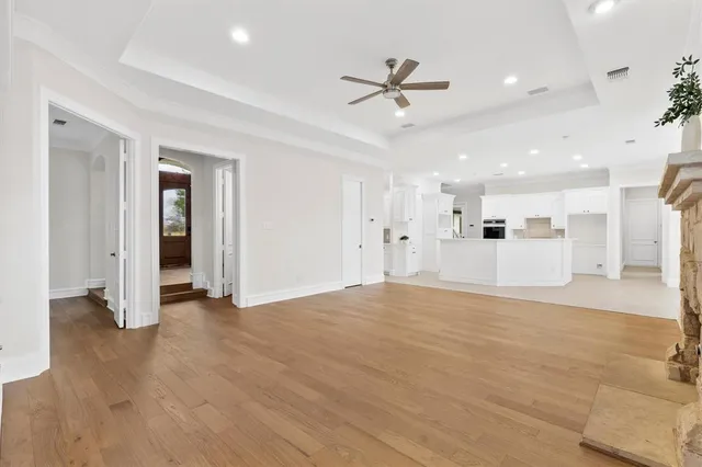 a view of empty room with wooden floor and ceiling fan