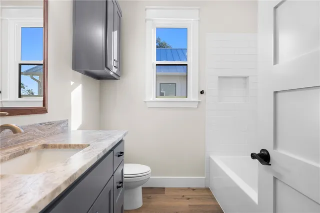 a bathroom with a granite countertop sink toilet and shower