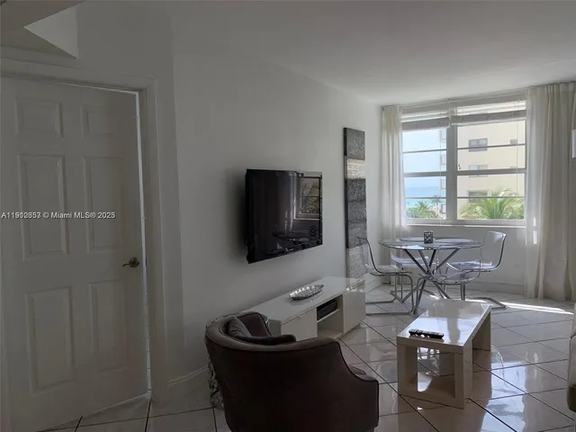 a living room with furniture a flat screen tv and a window