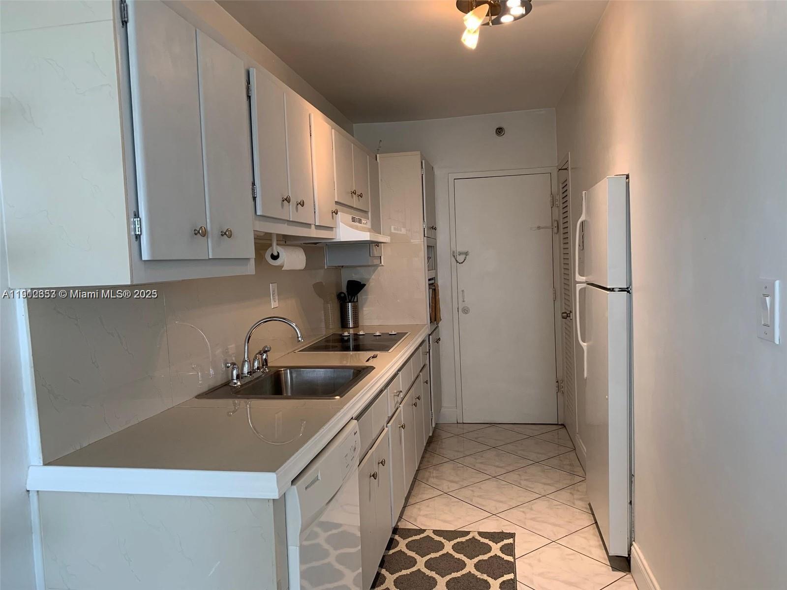 100 Lincoln Road, Unit 638 Miami Beach, FL 33139 - Photo 7 of 26 a kitchen with white cabinets and refrigerator