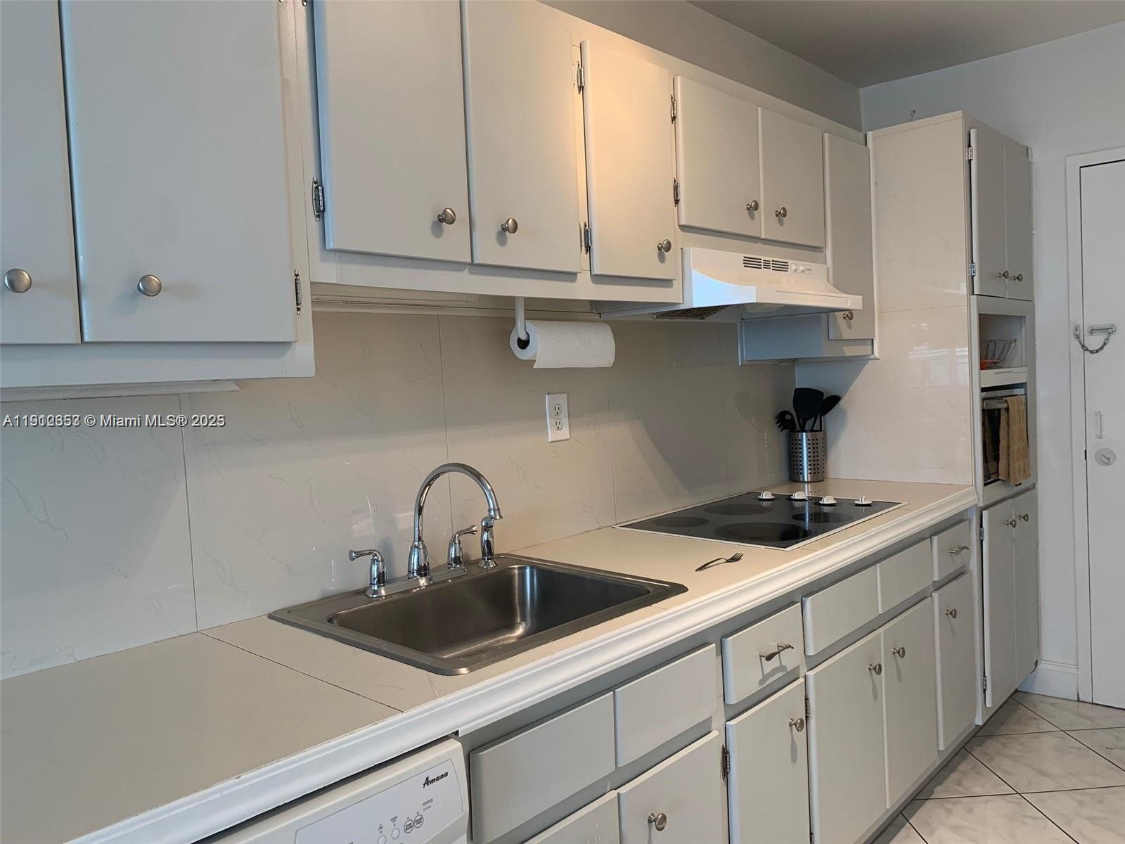 100 Lincoln Road, Unit 638 Miami Beach, FL 33139 - Photo 8 of 26 a kitchen with white cabinets a sink and dishwasher