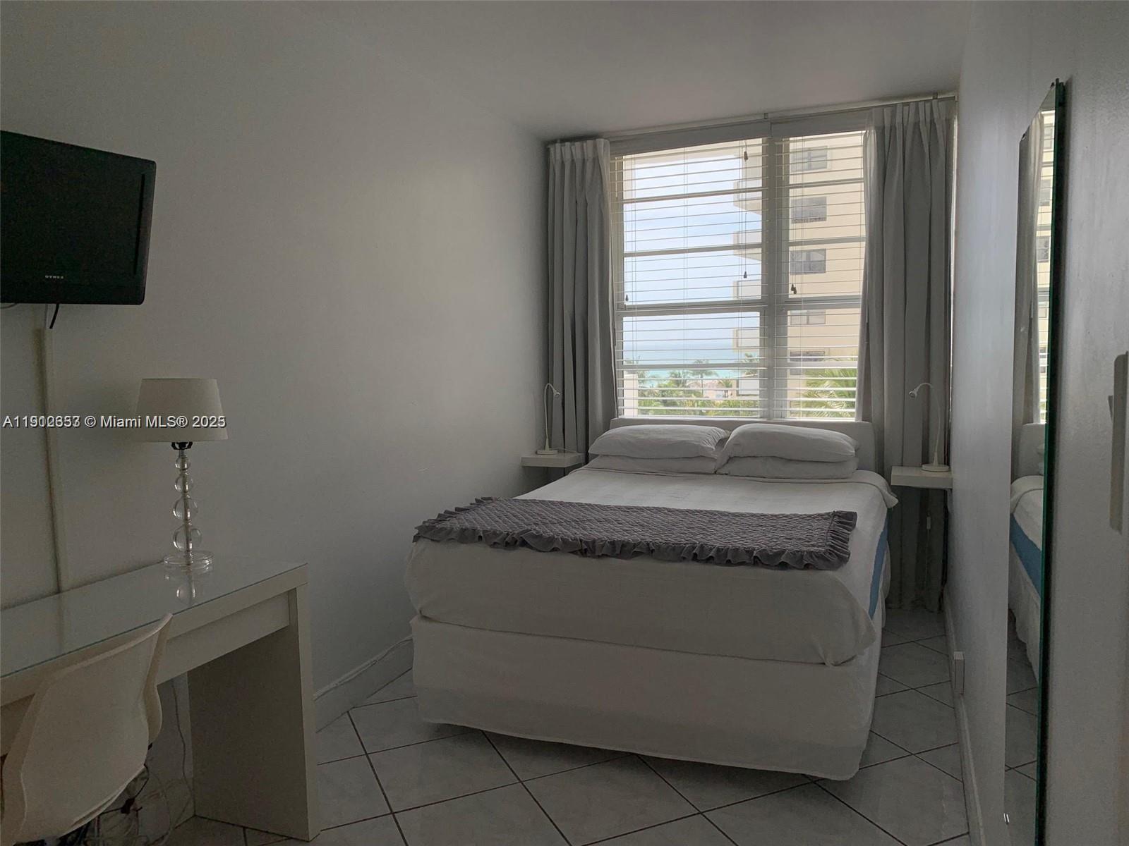 100 Lincoln Road, Unit 638 Miami Beach, FL 33139 - Photo 10 of 26 a spacious bedroom with a bed and a flat screen tv