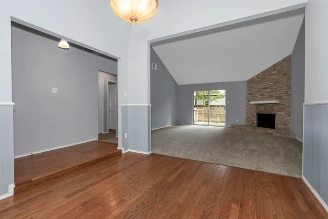 an empty room with fireplace and windows