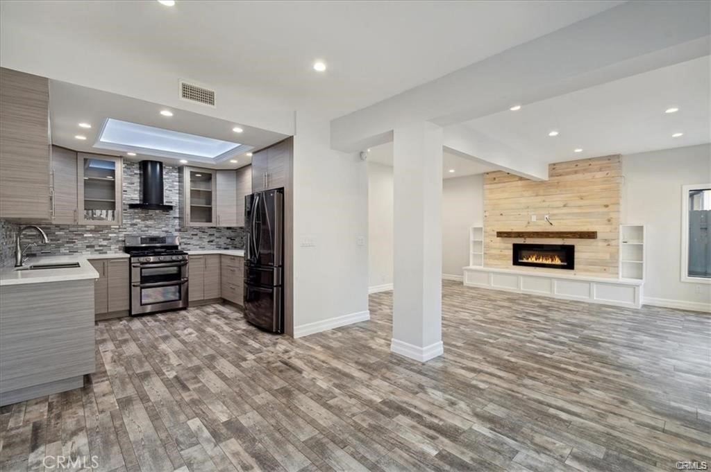 a kitchen with stainless steel appliances granite countertop a refrigerator stove oven and a sink