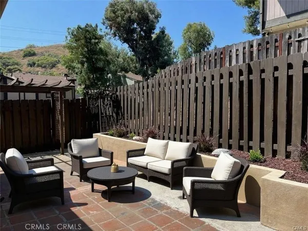 a patio with patio a couch and wooden fence