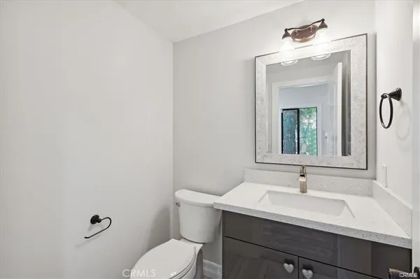 a bathroom with a sink vanity mirror and toilet