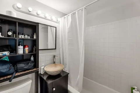 a bathroom with a granite countertop sink a toilet and a bathtub