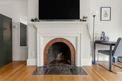 a view of a livingroom with fireplace and workspace