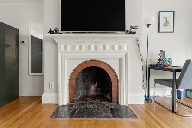 a view of a livingroom with fireplace and workspace