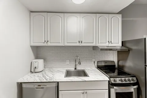 a kitchen with stainless steel appliances granite countertop a sink stove and cabinets