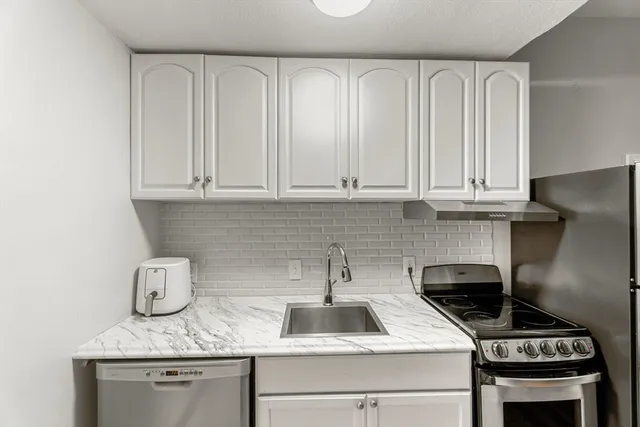 a kitchen with stainless steel appliances granite countertop a sink stove and cabinets