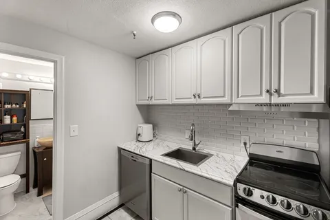 a kitchen with stainless steel appliances granite countertop a sink stove and cabinets
