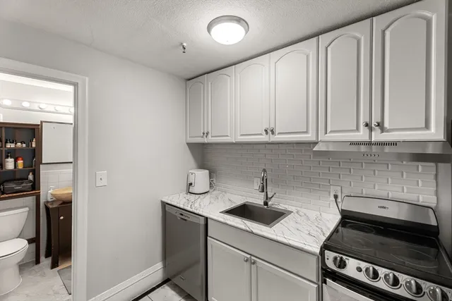 a kitchen with stainless steel appliances granite countertop a sink stove and cabinets
