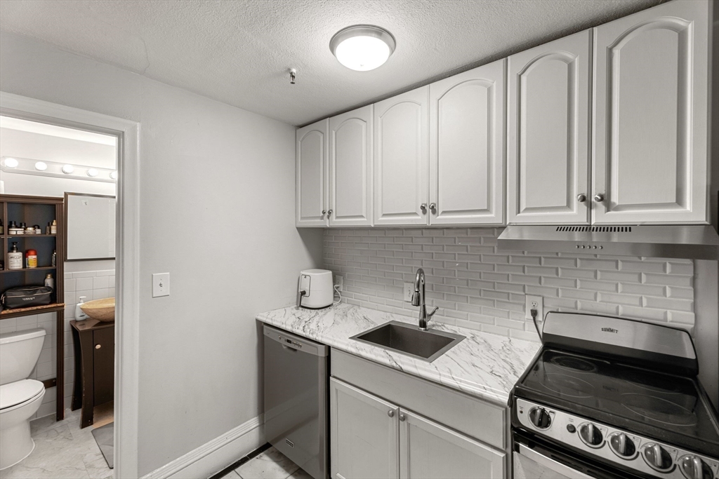 511 Beacon Street, Unit 11 Boston, MA 02215 - Photo 8 of 19 a kitchen with stainless steel appliances granite countertop a sink stove and cabinets