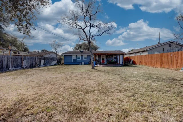a view of a house with backyard and a tree
