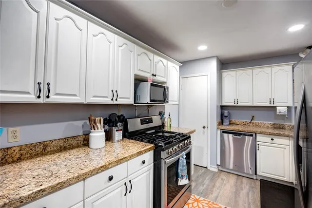 a kitchen with stainless steel appliances granite countertop a stove a sink and a microwave