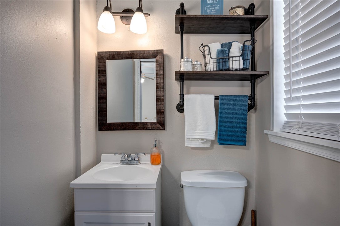 3906 Barnes Street Corpus Christi, TX 78415 - Photo 7 of 12 a bathroom with a toilet sink and mirror