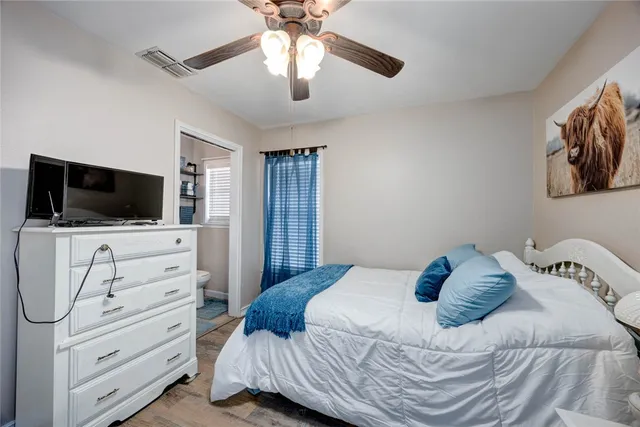 a bedroom with a bed and a flat tv screen on dresser
